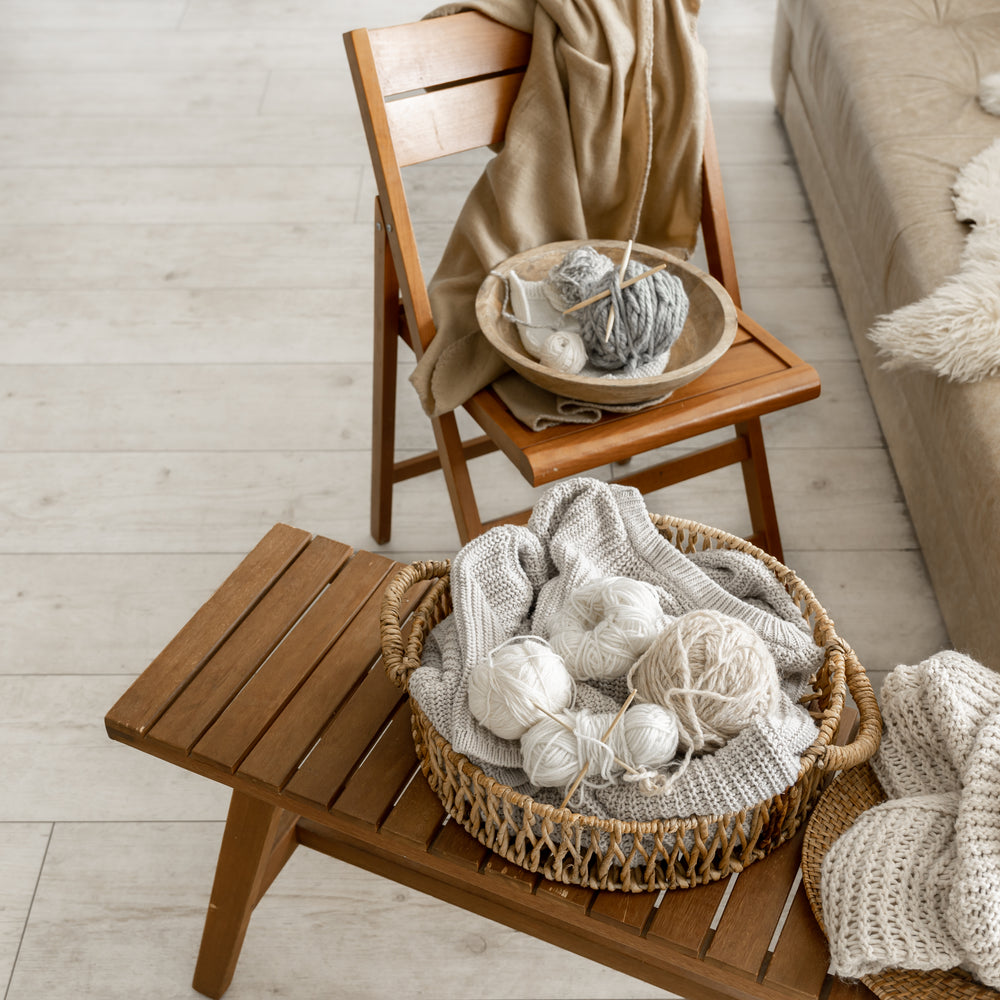 Yarn balls lay in a basket on top of a table